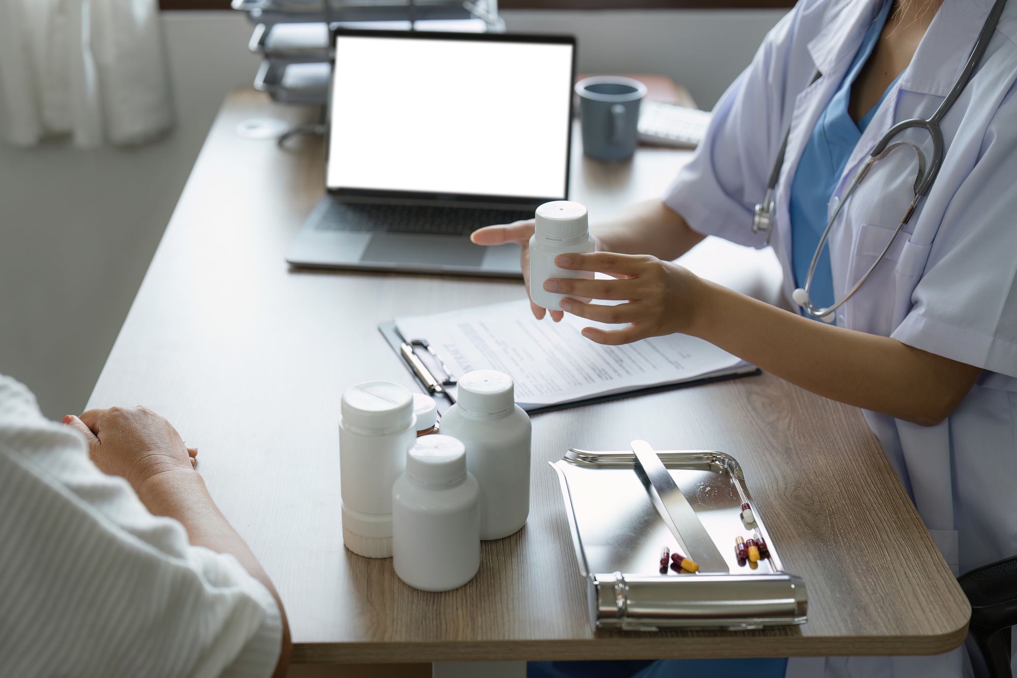 Doctor talking with elderly asian woman. Female primary care physician having conversation with